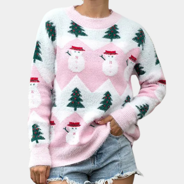 Roze kersttrui met sneeuwpop- en kerstboompatroon, gedragen door persoon in spijkershorts. Perfect voor feestdagen, wintermode, warme kleding.