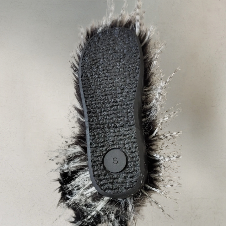 Zwarte rubberen zool van een harige pantoffel, maat S, met grijs-witte vachttextuur. Comfortabele, warme pantoffel voor thuisgebruik.