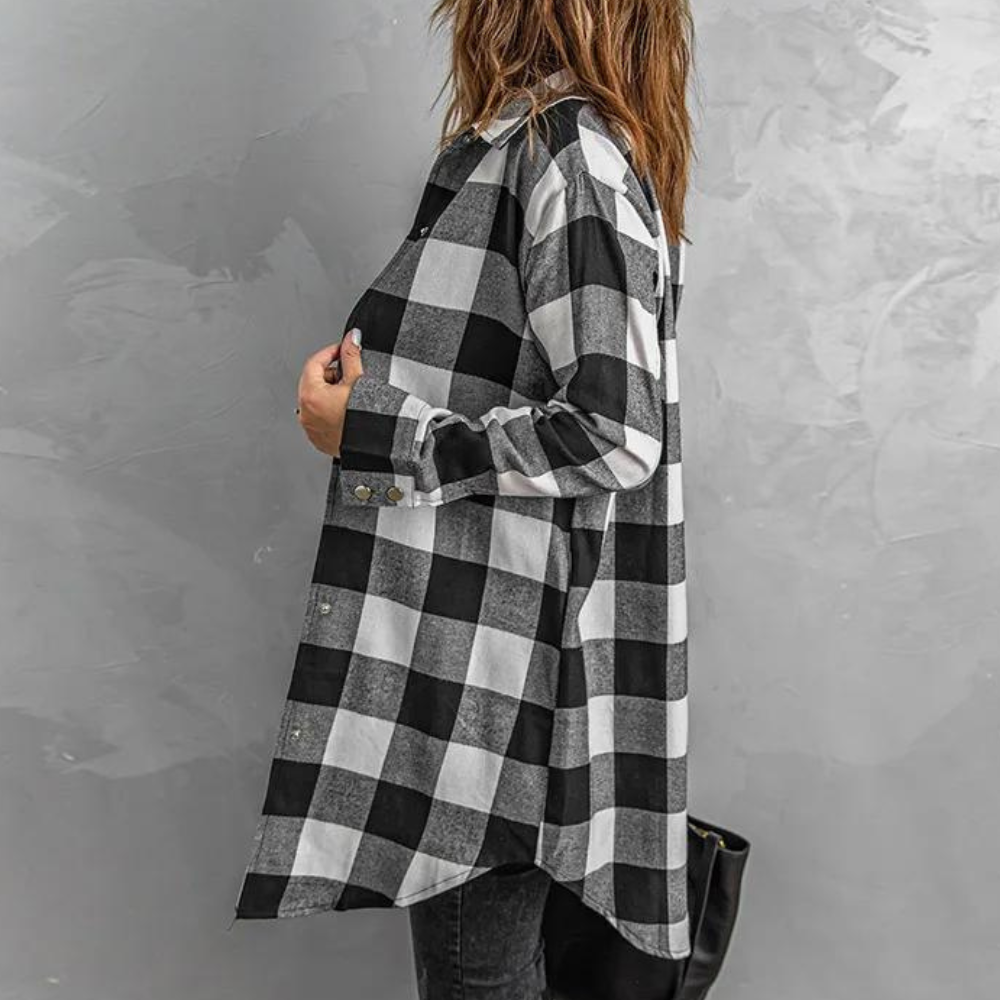 Vrouw in zwart-wit geruite blouse tegen grijze achtergrond, modieuze oversized stijl, casual dameskleding, herfstmode 2023.