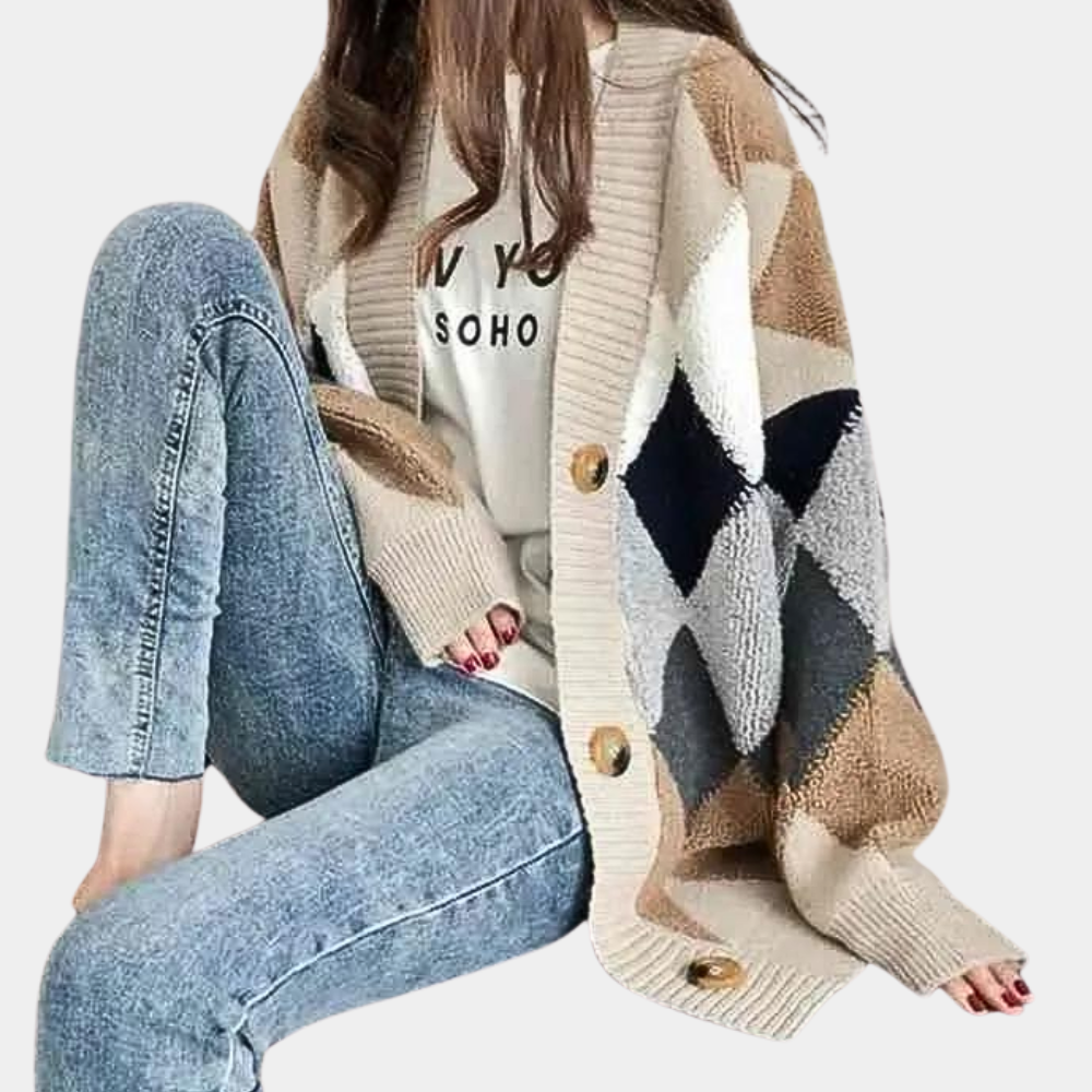 Vrouw draagt oversized gebreid vest met geometrisch patroon en knopen, gecombineerd met casual jeans en wit T-shirt. Modieuze herfstkleding.