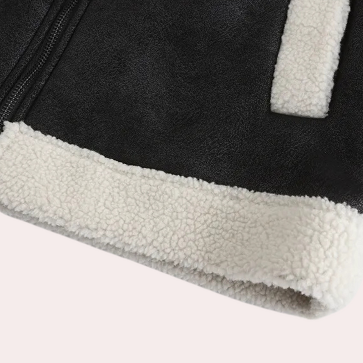Zwarte shearling jas met witte fleece voering, detail van rits en textuur. Stijlvolle wintermode, warme en comfortabele buitenkleding.