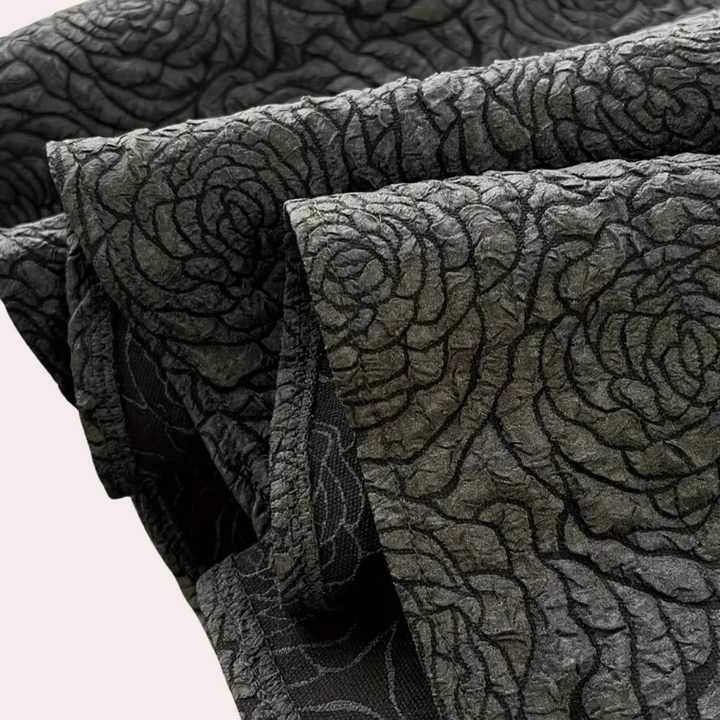 Donkergrijze jacquardstof met rozenpatroon, geschikt voor luxe interieurdecoratie en modeontwerp. Textiel, bloemenmotief, elegant design.
