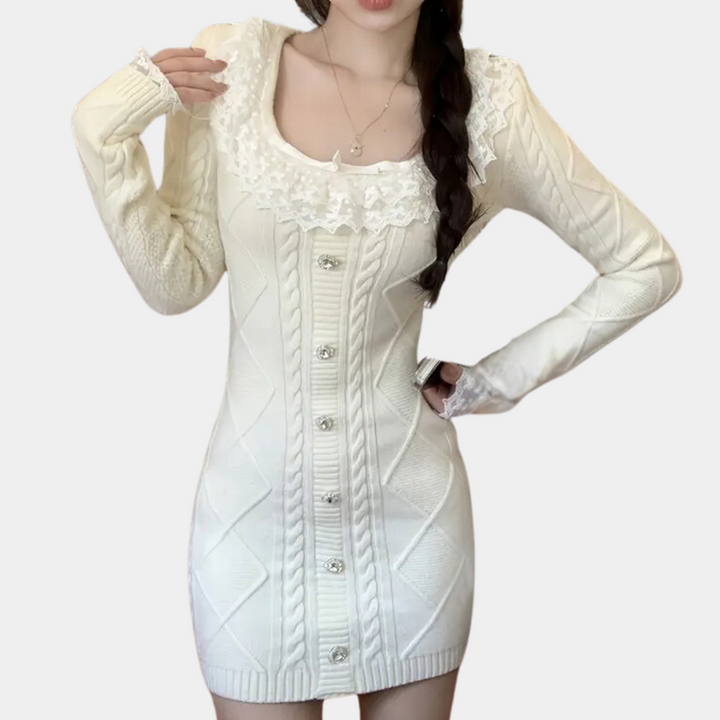 Witte gebreide jurk met lange mouwen, knoopsluiting en kanten details. Elegante damesmode, perfect voor herfst- en winterseizoen.