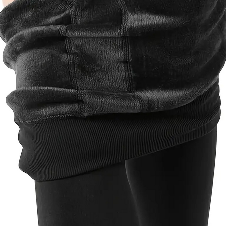 Zwarte fleece hoodie met geribde zoom, comfortabele pasvorm, warme winterkleding, casual mode, unisex design, detailopname stoftextuur.