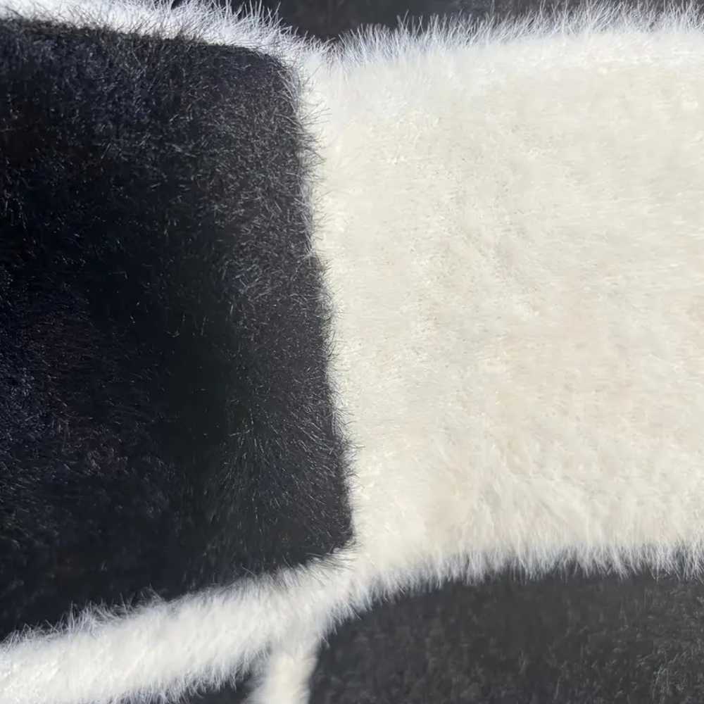 Zwart-witte pluche stof close-up, zachte textuur, geschikt voor knuffels en interieurdecoratie, luxe en comfortabel materiaal.