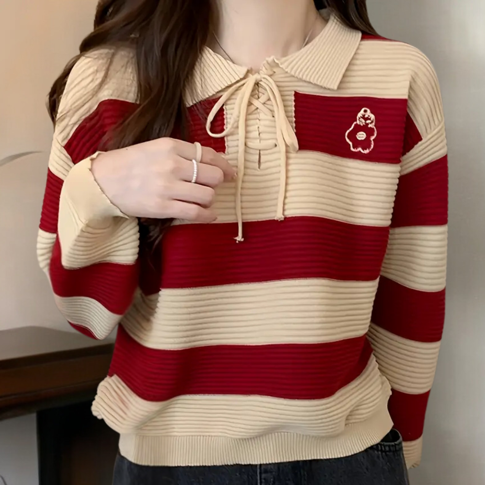 Vrouw draagt rood-beige gestreepte trui met kraag en bloemenpatch, casual mode, herfstkleding, trendy damestrui, comfortabele outfit.