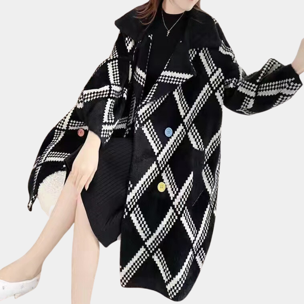 Vrouw draagt een stijlvolle zwart-witte geruite jas met kleurrijke knopen, zittend op een witte achtergrond. Wintermode, trendy dameskleding.