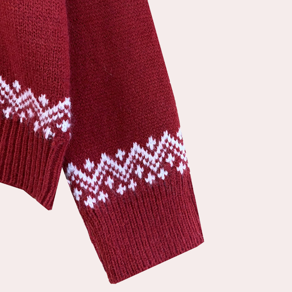 Rode gebreide trui met witte Noorse patronen, close-up van mouw. Wintermode, warme kleding, Scandinavisch design, comfortabele trui.