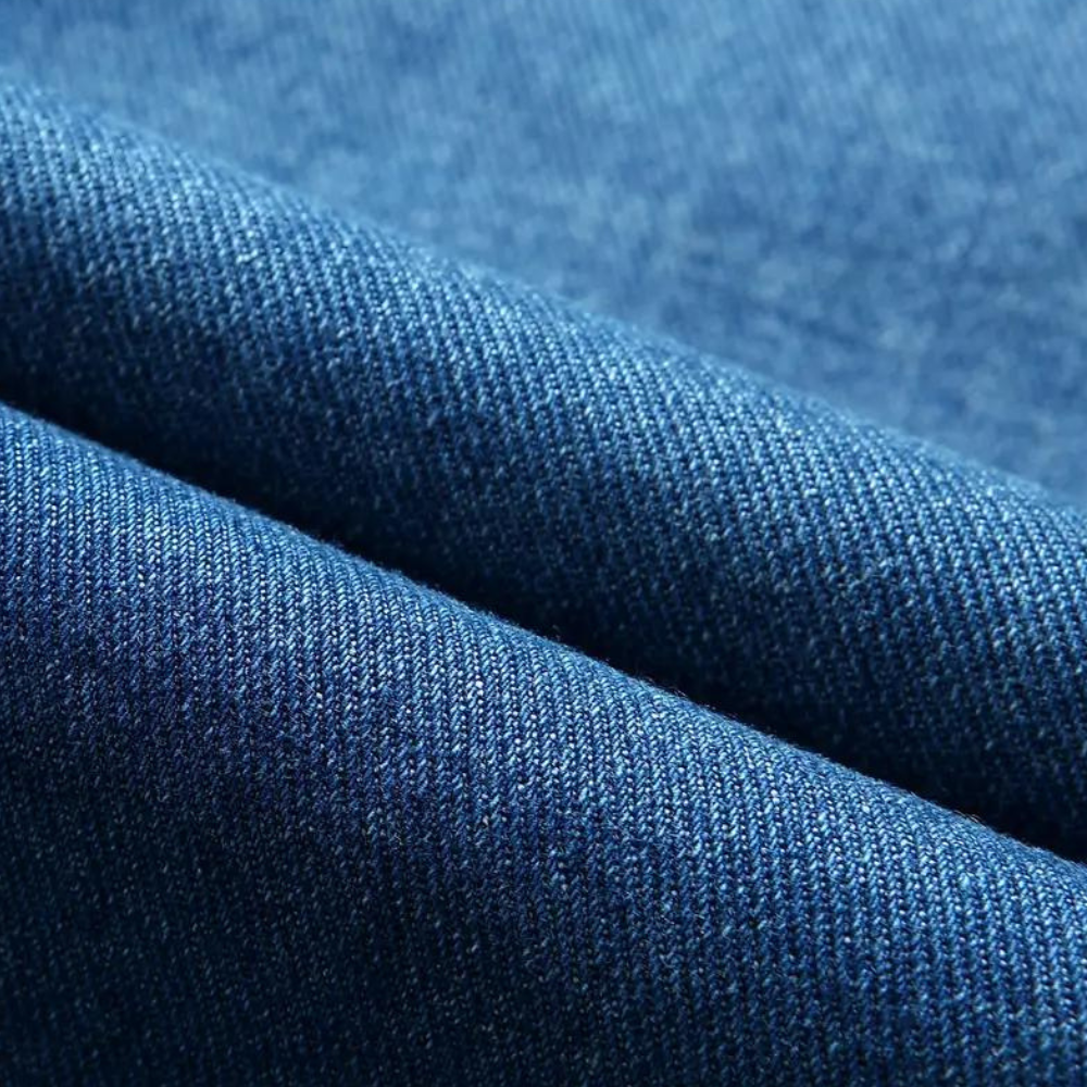 Blauwe denim stof close-up, textuur van hoogwaardige jeansstof, ideaal voor modeontwerp en kledingproductie.