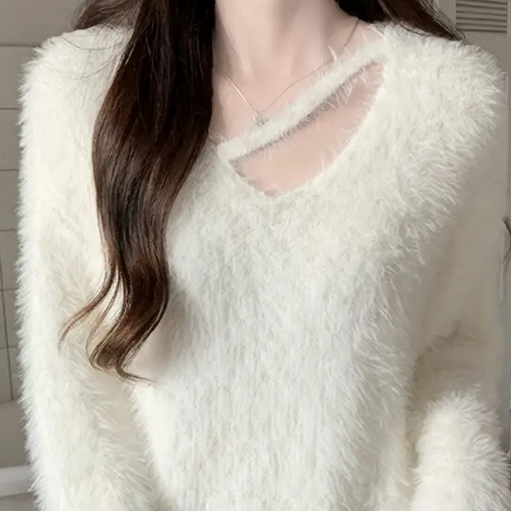Witte pluizige trui met V-hals en subtiele uitsnede, gedragen door vrouw. Modieuze dameskleding, wintertrui, zachte textuur, trendy design.