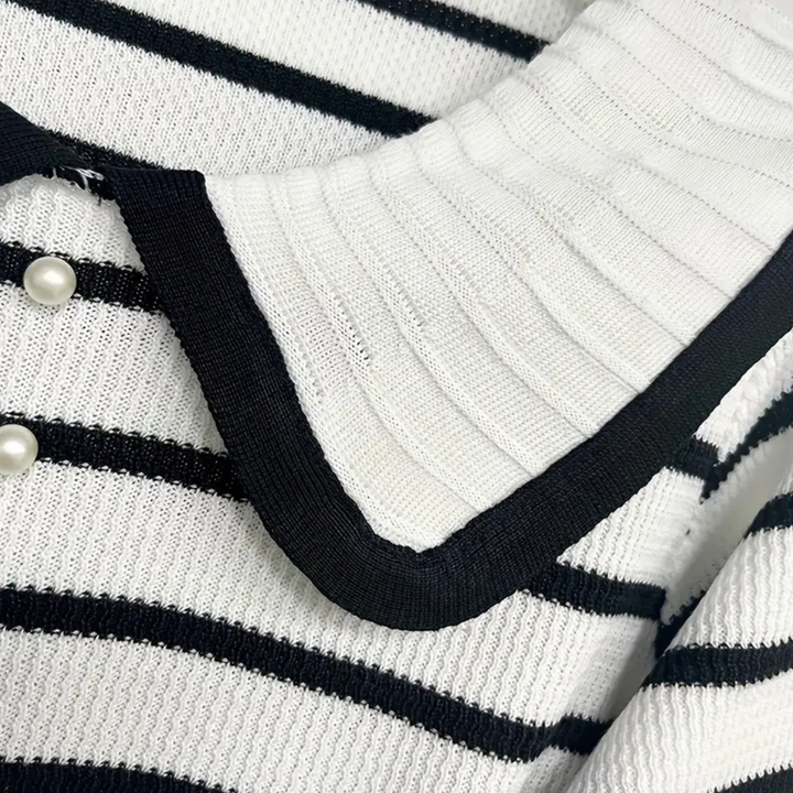 Gestreepte trui met zwart-witte strepen, grote kraag en parelknopen. Modieuze dameskleding, trendy design, comfortabele stof.