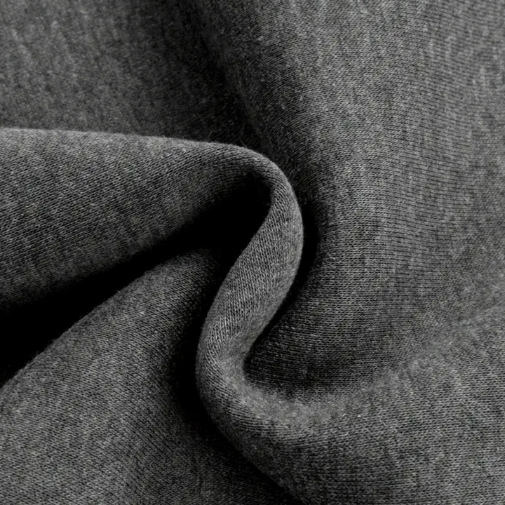 Grijze jersey stof close-up, zachte textuur, hoogwaardige breisel, ideaal voor kleding en interieur, duurzaam en comfortabel materiaal.
