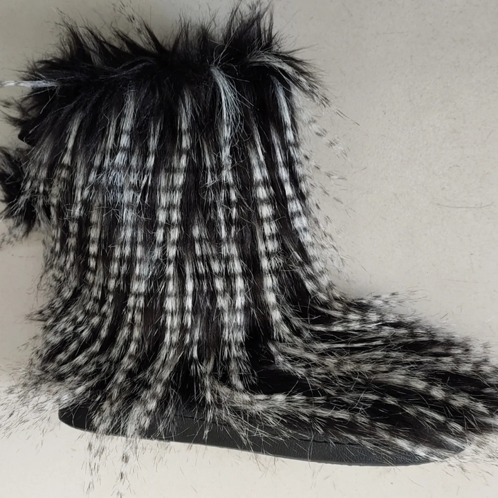 Zwart-witte bontlaars met gestreept patroon, pluizige textuur en stevige zool. Modieuze winterlaars voor dames. Warm en stijlvol schoeisel.