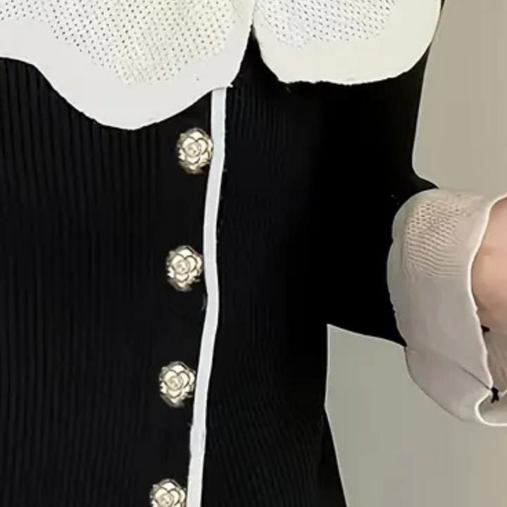 Zwart geribbelde jurk met witte kraag en bloemknopen, elegante damesmode, stijlvolle kleding, close-up detail, modetrend 2023.