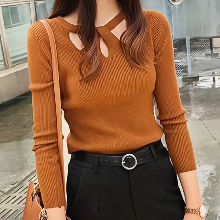 Vrouw in stijlvolle bruine trui met uitgesneden details, zwarte broek en bruine tas. Modieuze herfstkleding, trendy damesmode, casual chic outfit.