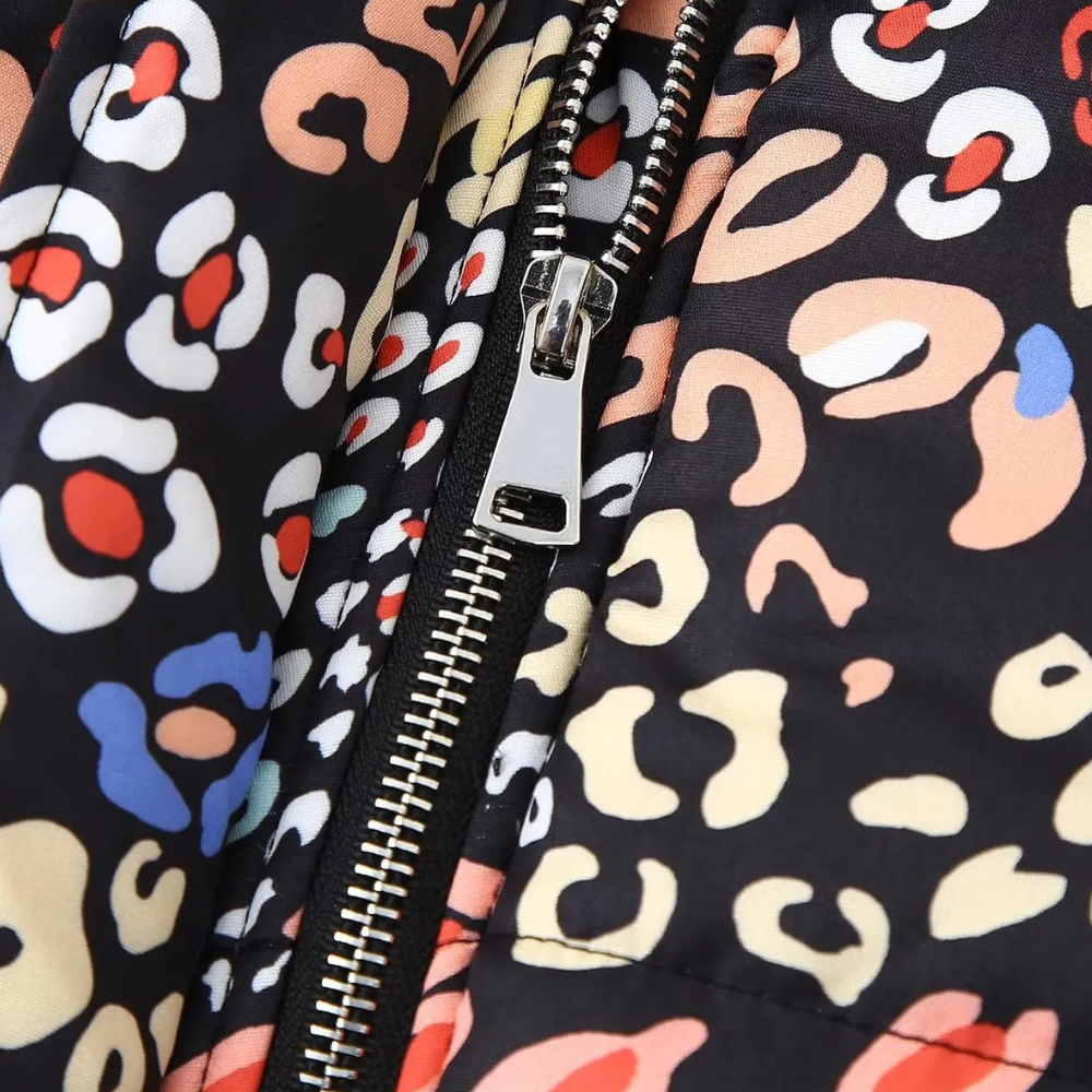 Close-up van kleurrijke luipaardprint jas met ritssluiting, modetrend, herfstkleding, opvallend patroon, stijlvolle damesjas, detailopname.