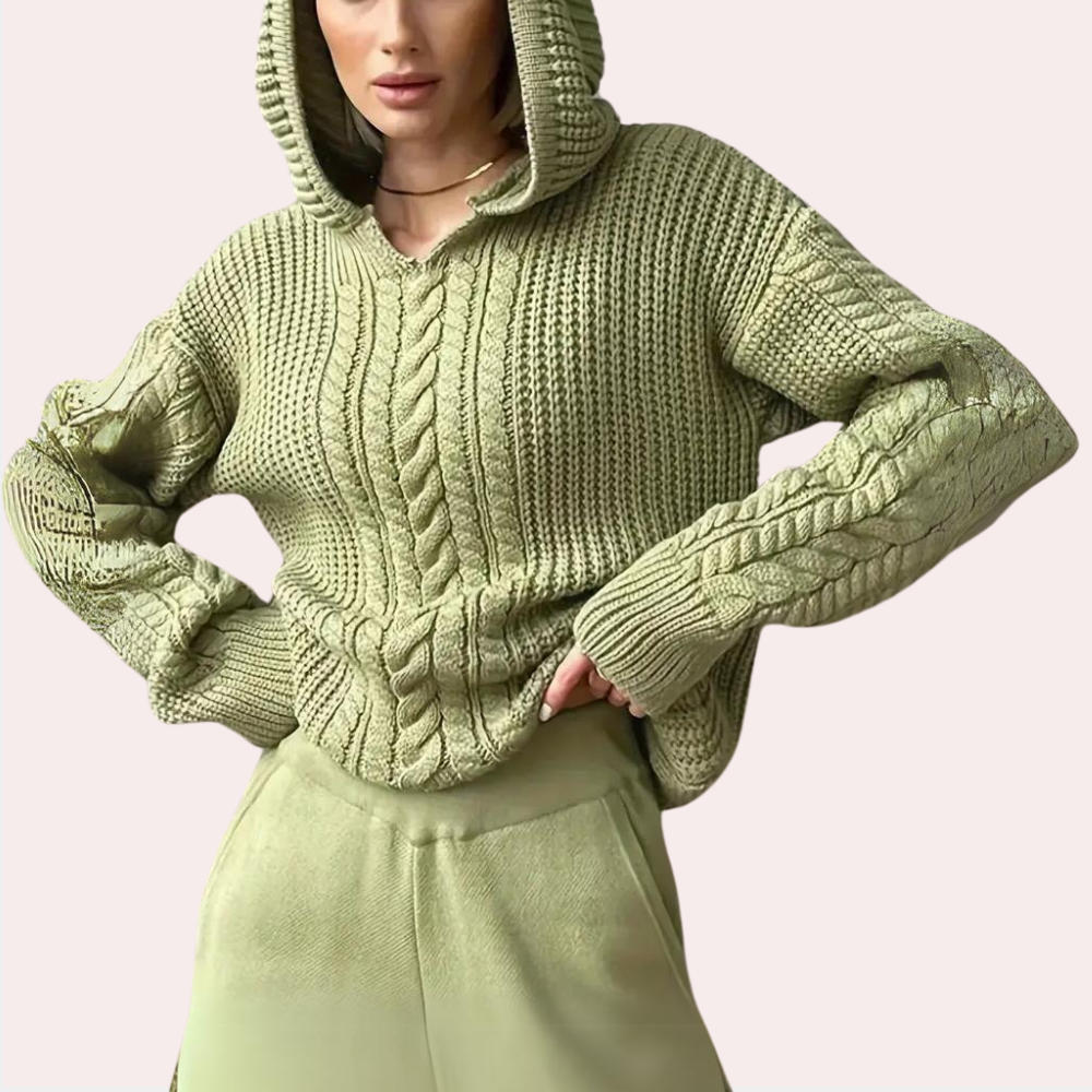 Vrouw in olijfgroene gebreide hoodie met kabelpatroon, comfortabele pasvorm. Modieuze dameskleding, herfsttrui, casual stijl.