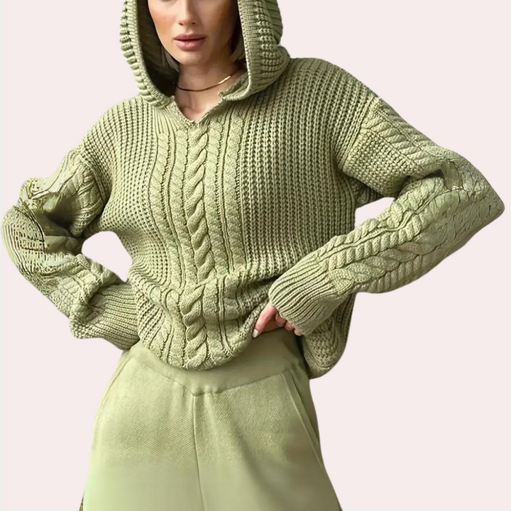 Vrouw in olijfgroene gebreide hoodie met kabelpatroon, comfortabele pasvorm. Modieuze dameskleding, herfsttrui, casual stijl.