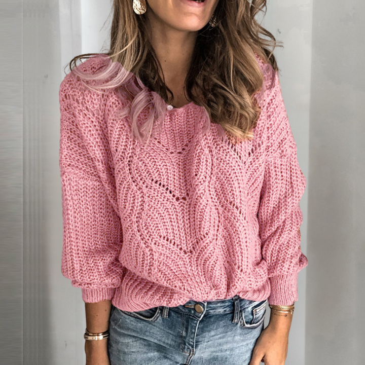 Vrouw draagt roze gebreide trui met kabelpatroon, casual mode, herfstkleding, trendy dameskleding, stijlvolle outfit, comfortabele trui.