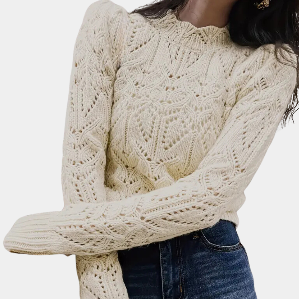 Beige gebreide trui met kabelpatroon, lange mouwen en ronde hals, gedragen door model. Perfect voor herfstmode en casual outfits.