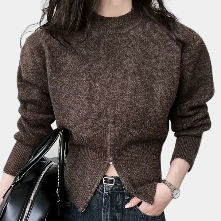 Vrouw in bruine trui met ritssluiting, zwarte leren tas en spijkerbroek. Modieuze herfstkleding, casual stijl, damesmode.