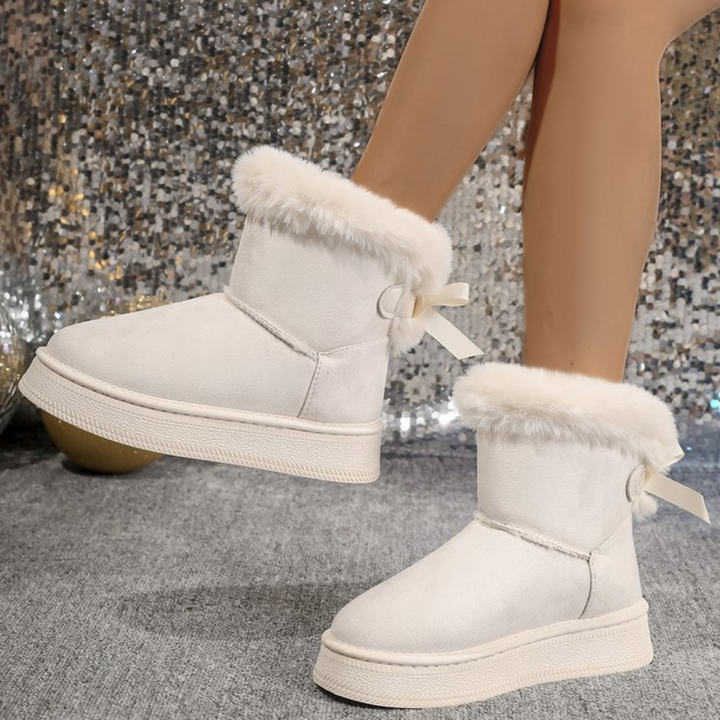 Witte dameslaarzen met bontvoering en strikdetail, comfortabele wintermode, trendy schoeisel voor koude dagen, stijlvolle en warme laarzen.