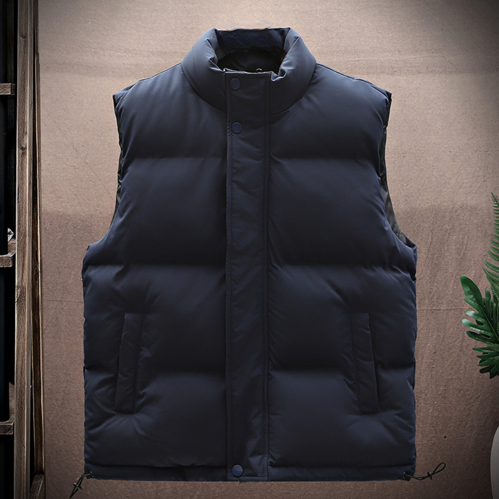 Donkerblauwe gewatteerde bodywarmer, mouwloos, met opstaande kraag en knoopsluiting. Ideaal voor herfst- en wintermode. Comfortabel en stijlvol.