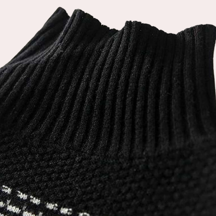 Zwarte gebreide coltrui met geribbelde kraag, close-up. Modieuze winterkleding, warme trui voor dames en heren, comfortabele pasvorm.