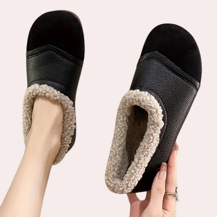 Zwarte leren pantoffels met zachte voering, comfortabele winterse huisschoenen voor dames, warme en stijlvolle sloffen voor binnenshuis gebruik.