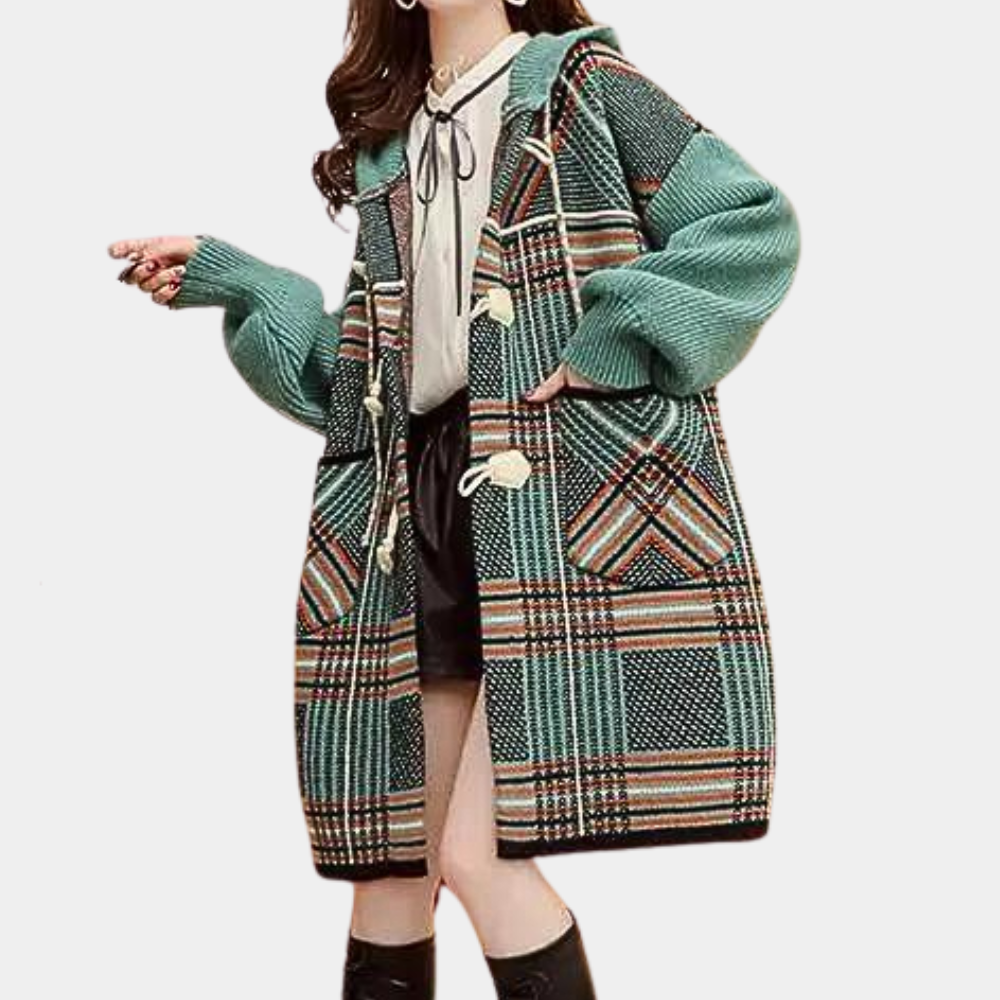 Vrouw in oversized geruite jas met groene en bruine tinten, grote knopen en capuchon. Modieuze herfst- en winterkleding voor dames.