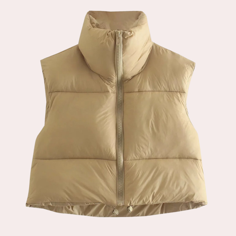 Beige gewatteerd dames bodywarmer met hoge kraag en ritssluiting, ideaal voor herfst- en wintermode. Stijlvolle en warme kledingoptie.