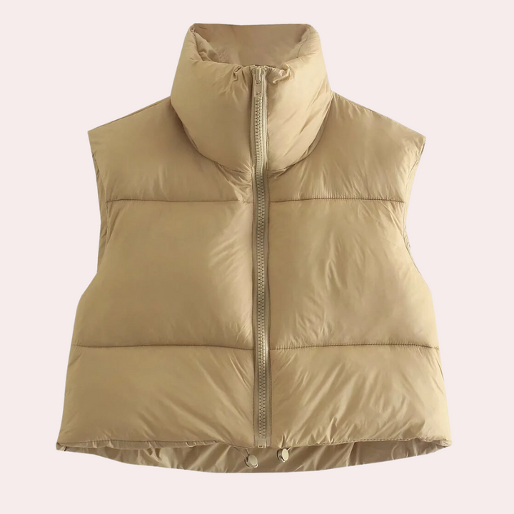 Beige gewatteerd dames bodywarmer met hoge kraag en ritssluiting, ideaal voor herfst- en wintermode. Stijlvolle en warme kledingoptie.