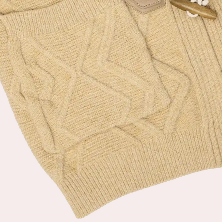 Beige gebreide trui met kabelpatroon, close-up. Zachte wol, warme textuur, modieuze herenkleding. Perfect voor herfst- en winterseizoenen.