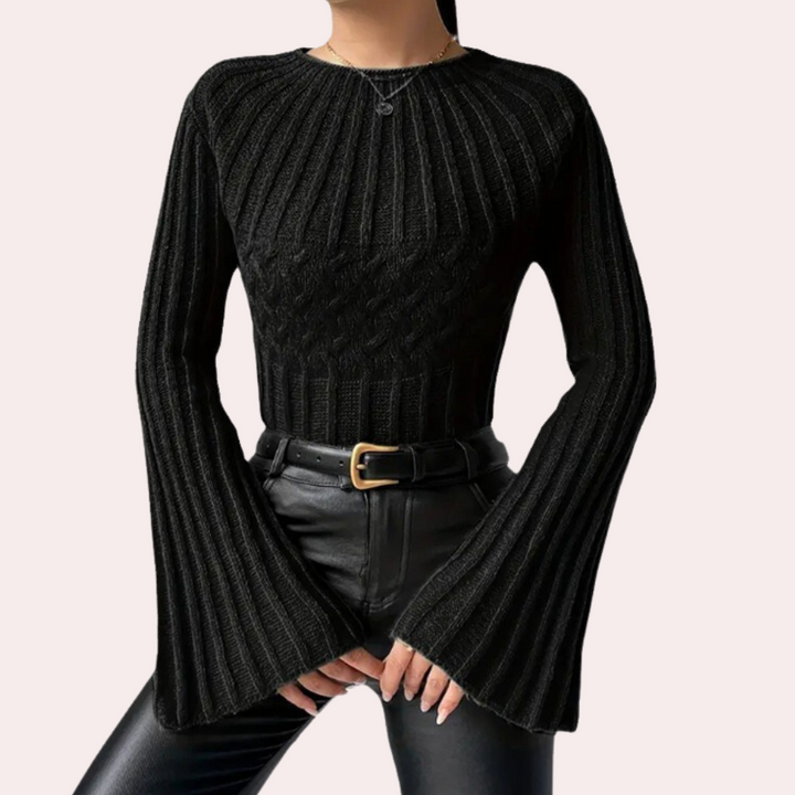 Zwarte gebreide trui met wijde mouwen, gedragen door model. Modieuze dameskleding, perfect voor herfst en winter. Comfortabel en stijlvol design.