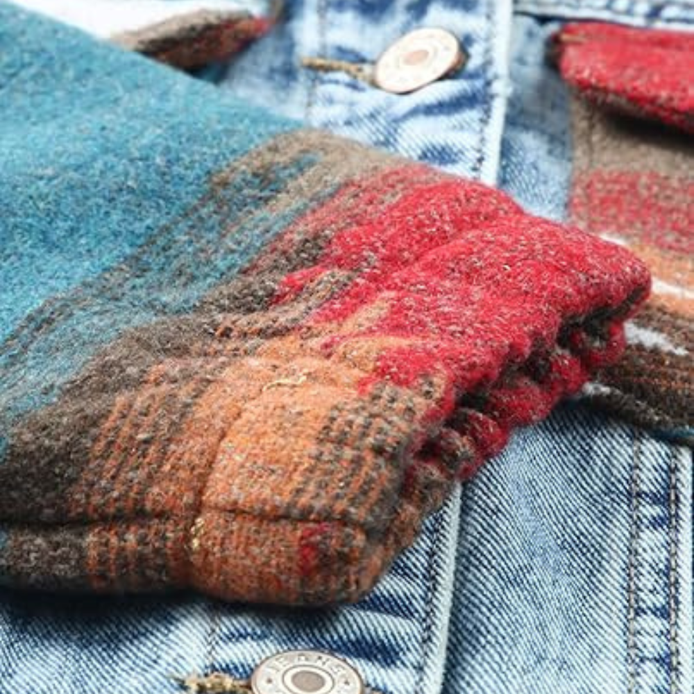 Detail van een kleurrijke wollen mouw op een blauwe spijkerjas. Modieuze winterkleding, textuur en patroon, warme stoffen, casual stijl.