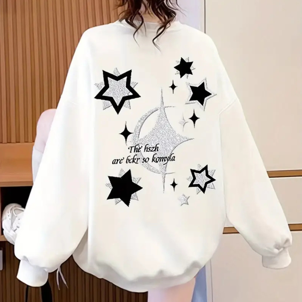 Witte oversized trui met zwarte en zilveren sterontwerpen, tekst "The fish are bkt so komyla", trendy mode, casual streetwear, dameskleding.