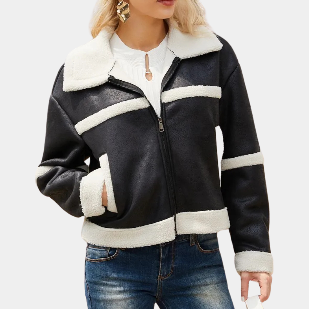 Zwarte damesjas met witte schapenvacht voering, ritssluiting en zakken. Modieuze winterjas, ideaal voor casual en warme winteroutfits.