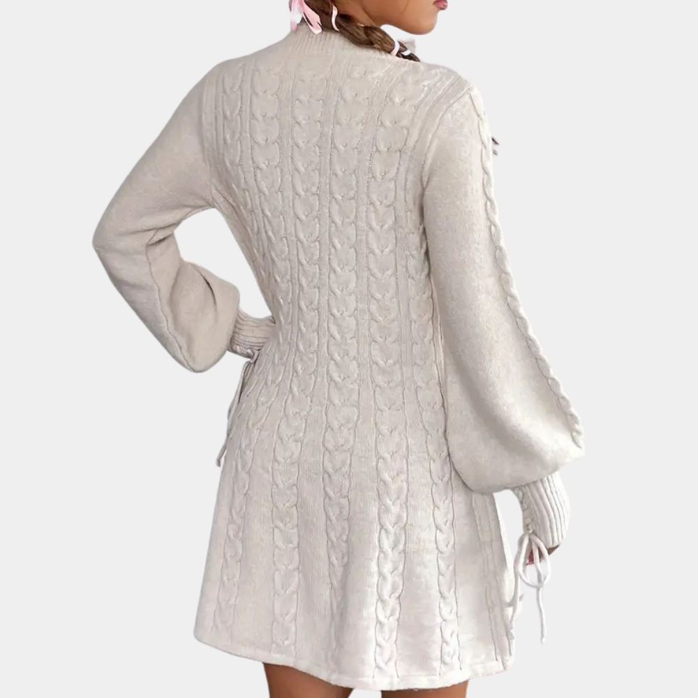 Vrouw in gebreide witte jurk met kabelpatroon en lange mouwen, rugaanzicht. Modieuze dameskleding, herfst-winter stijl, elegant design.