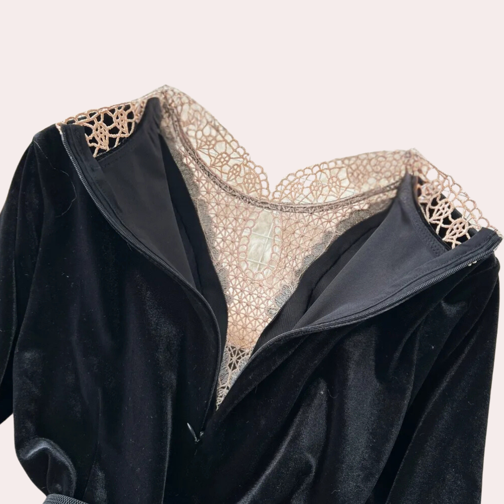 Zwarte fluwelen jurk met delicate kanten details bij de halslijn en schouders, elegante avondkleding, modieuze dameskleding, luxe uitstraling.
