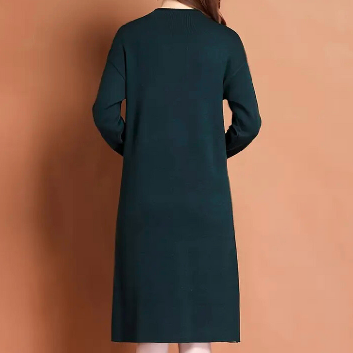 Donkergroene damesjurk met lange mouwen, rugaanzicht. Elegante, casual stijl, perfect voor herfst- en wintermode. Comfortabele pasvorm.