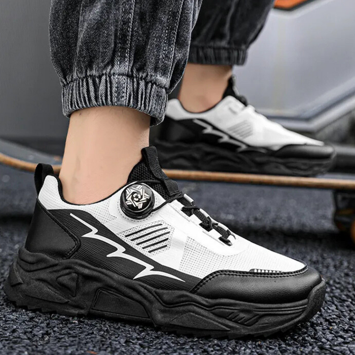 Zwart-witte sportschoenen met dikke zool en opvallend ontwerp, gedragen door persoon op skateboard. Trendy sneakers voor skateboarden en casual stijl.