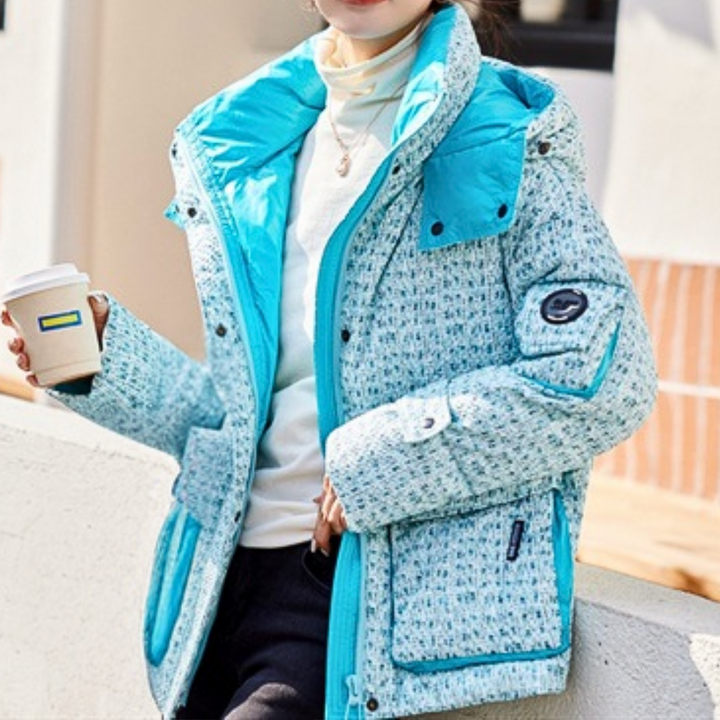 Vrouw in blauwe winterjas met koffie, buiten. Modieuze damesjas, warme kleding, wintermode, casual stijl, comfortabele buitenkleding.