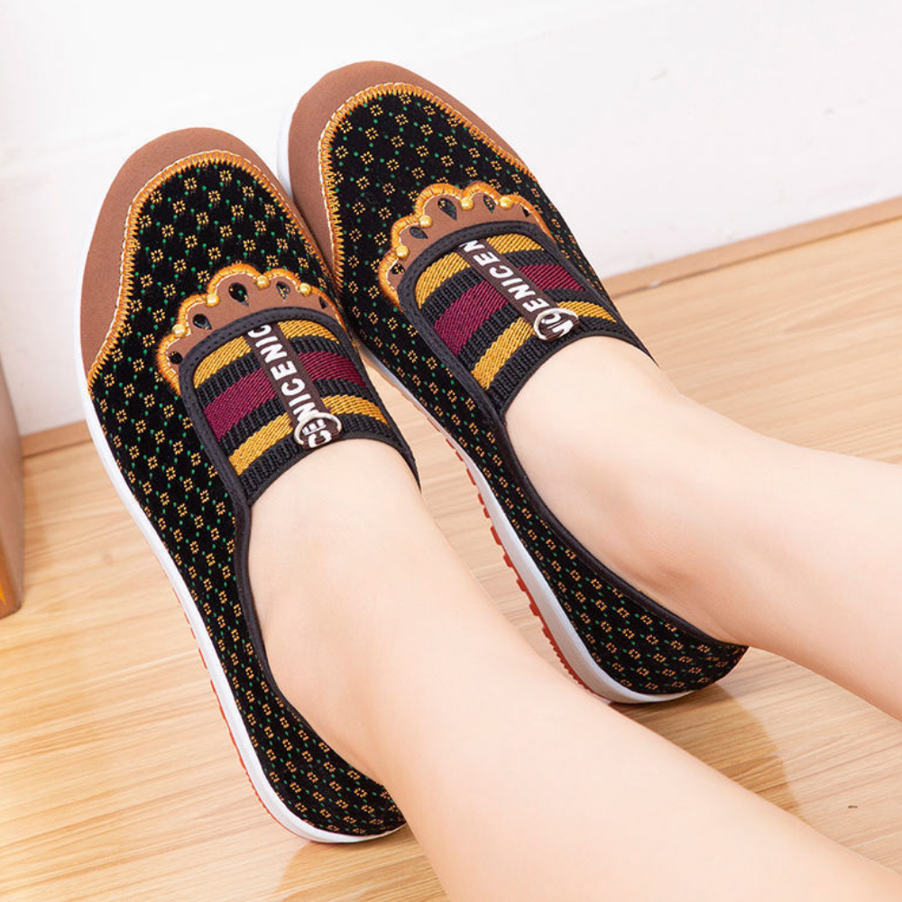 Zwart-geel gestreepte damesschoenen met kleurrijk patroon en merklogo, comfortabele platte zool, perfect voor casual en modieuze outfits.