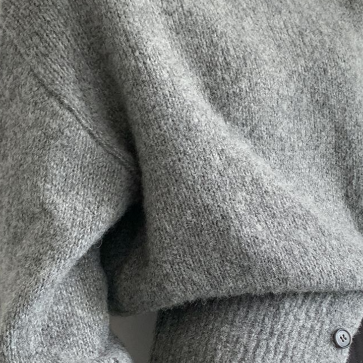 Grijze wollen trui close-up, zachte textuur, comfortabele wintermode, gebreide kleding, stijlvolle dameskleding, warme trui details.