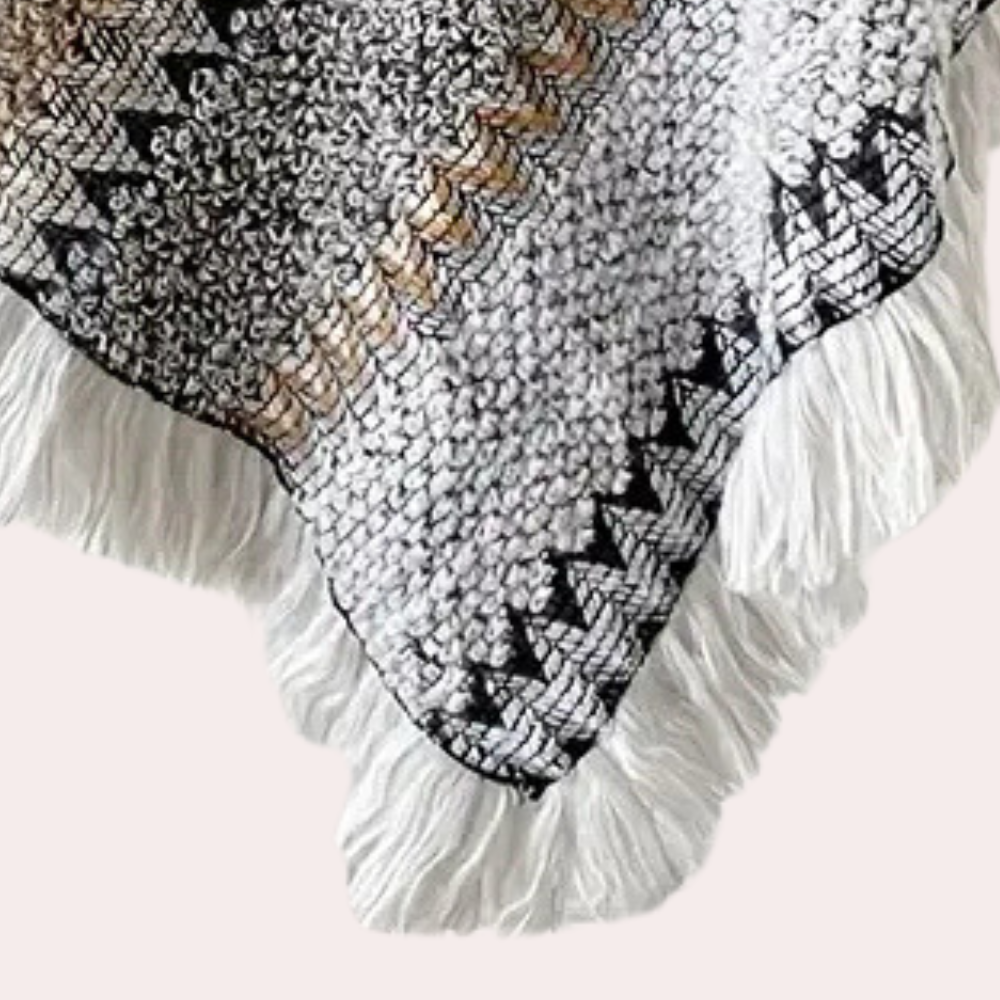 Gehaakte deken met zwart-wit geometrisch patroon en franjes, bohemian stijl, handgemaakt, perfect voor interieurdecoratie en gezellige woonkamers.