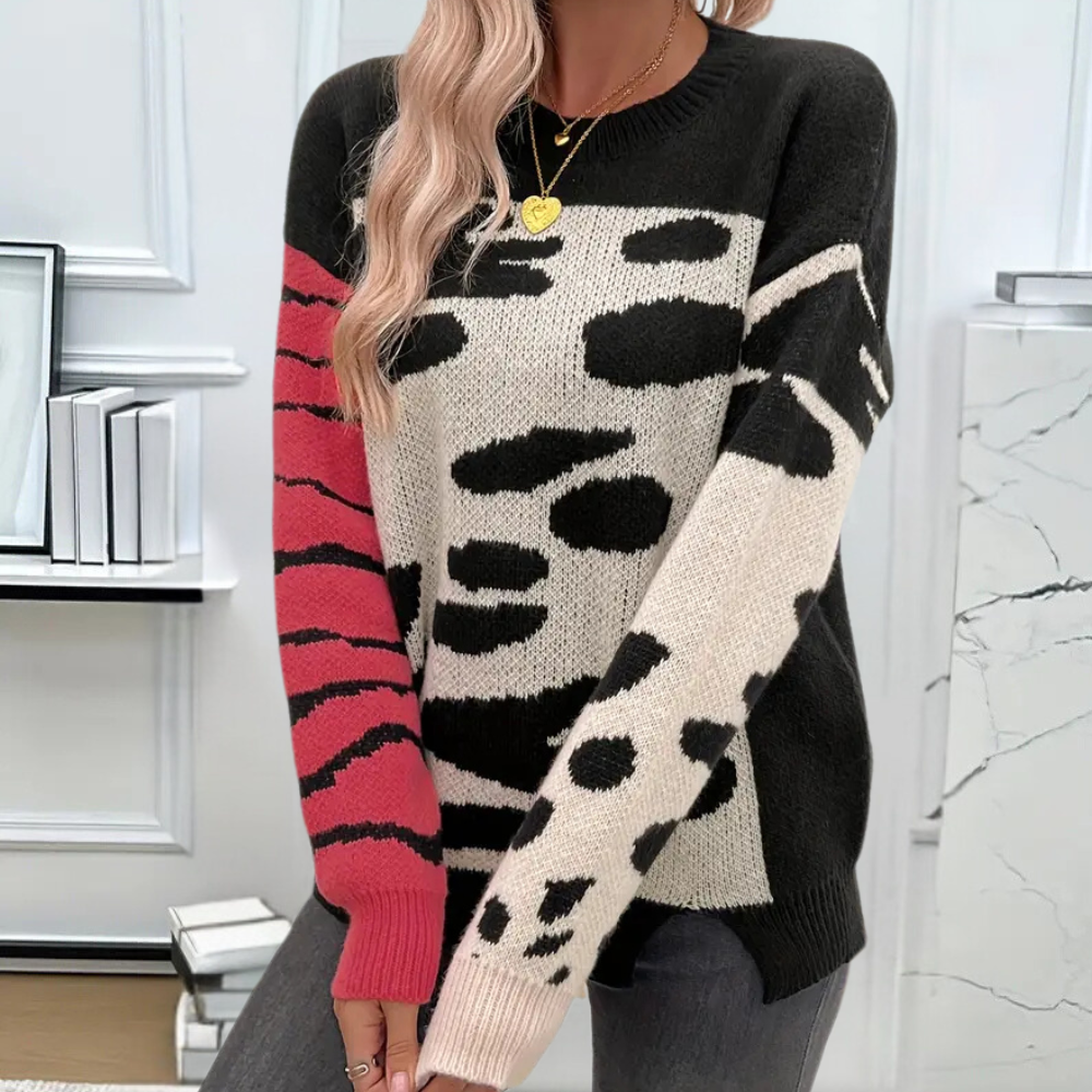 Vrouw draagt stijlvolle trui met zwart-witte dierenprint en roze accenten. Perfect voor modieuze herfst- en winteroutfits. Trendy damesmode.