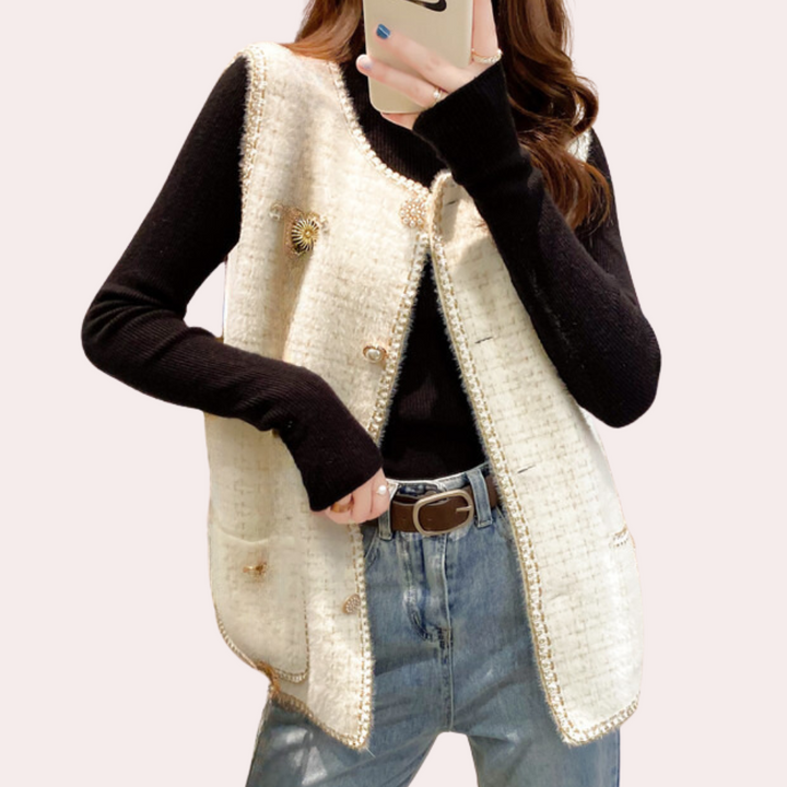 Vrouw in stijlvolle outfit met witte tweed gilet, zwarte trui en blauwe jeans. Modieuze dameskleding, herfstmode, casual chique look.