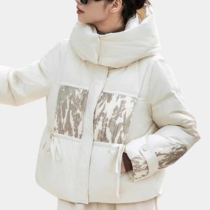Witte gewatteerde winterjas met hoge kraag en abstract patroon, gedragen door vrouw. Modieuze damesjas, warme winterkleding, trendy design.