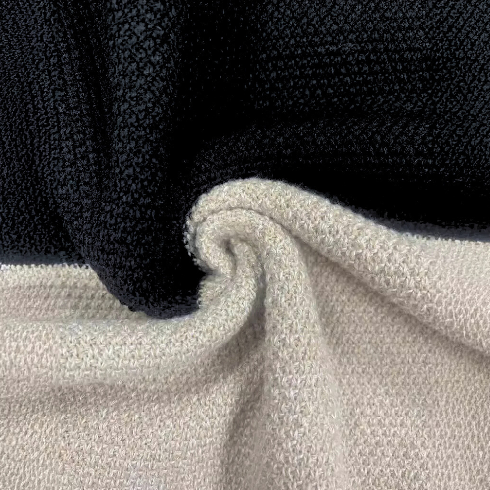 Zwart en beige gebreide stof, gedraaid in een spiraalvorm. Textiel, breiwerk, mode, interieurdecoratie, close-up textuur.
