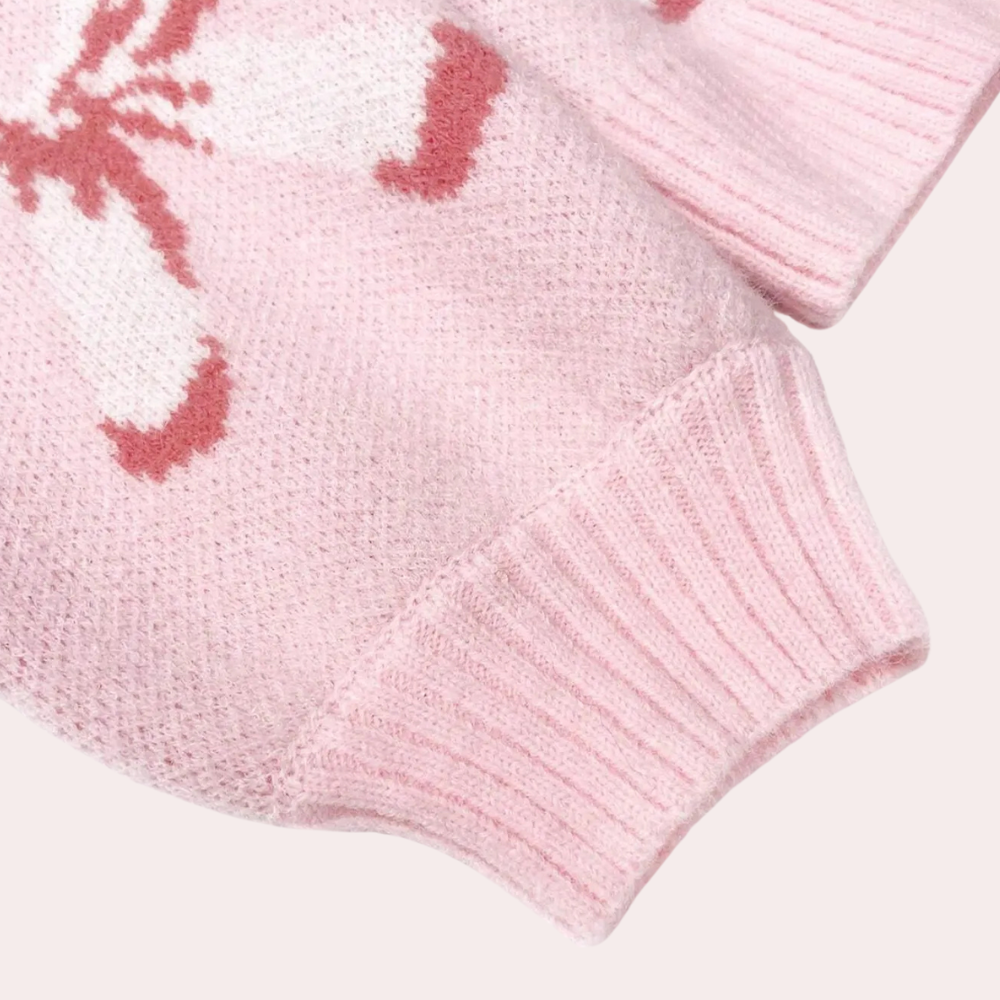 Roze gebreide trui met witte en rode vlinderprint, zachte stof, geribbelde manchetten, trendy damesmode, comfortabele winterkleding.